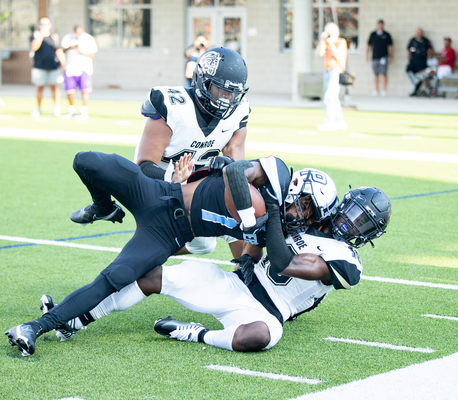 Paetow Derrick Johnson runs over a defender during Friday’s game against Conroe at Legacy Stadium.
